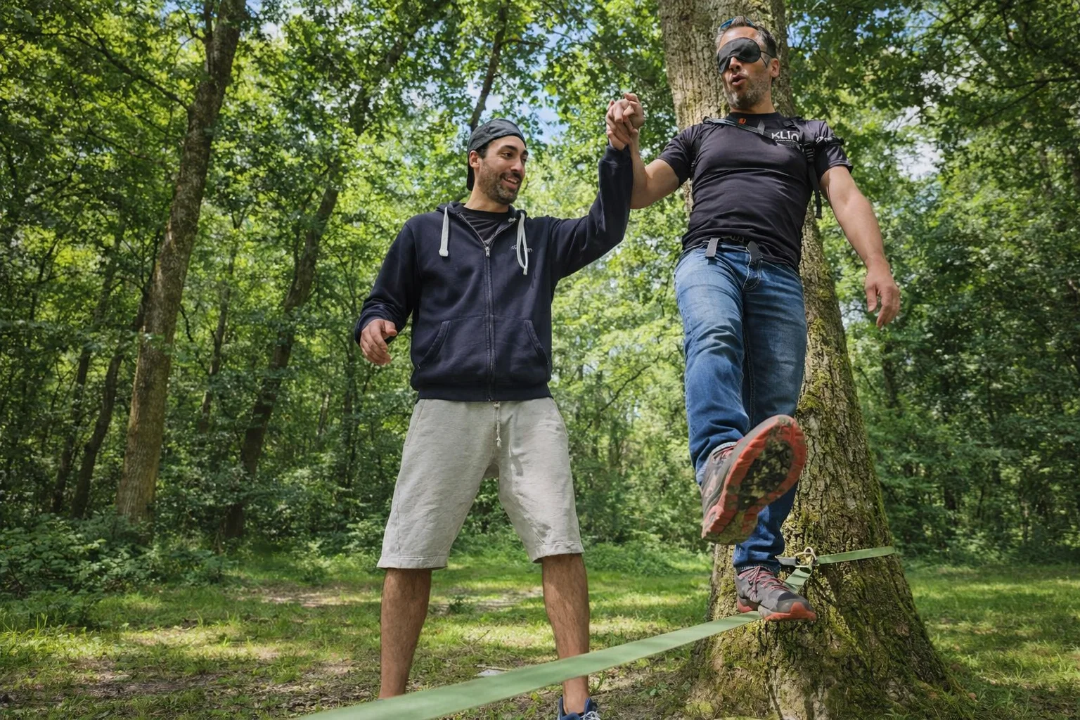 Slackline les yeux bandés avec aide d'un coéquipier - défi confiance en soi en forêt